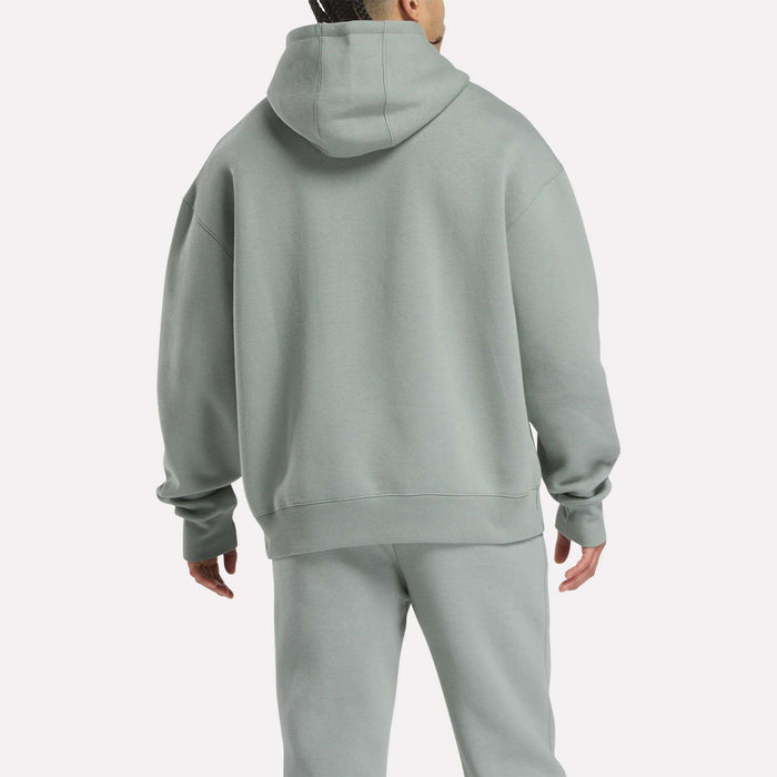 A person is shown from the back in a relaxed fit, light gray Men's Crest Hoodie and matching Reebok sweatpants made of soft fleece, set against a plain white background.