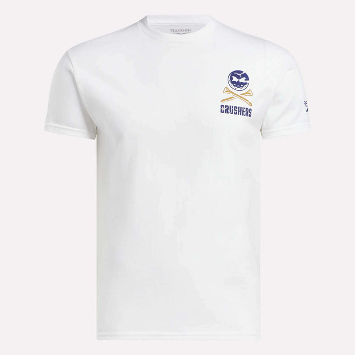 The Men's Crushers Stacked Logo Tee by Reebok features a white short-sleeve design with a purple and gold CRUSHERS cartoon logo on the left chest, just like Bryson DeChambeau's team, and a small Reebok logo on the left sleeve.