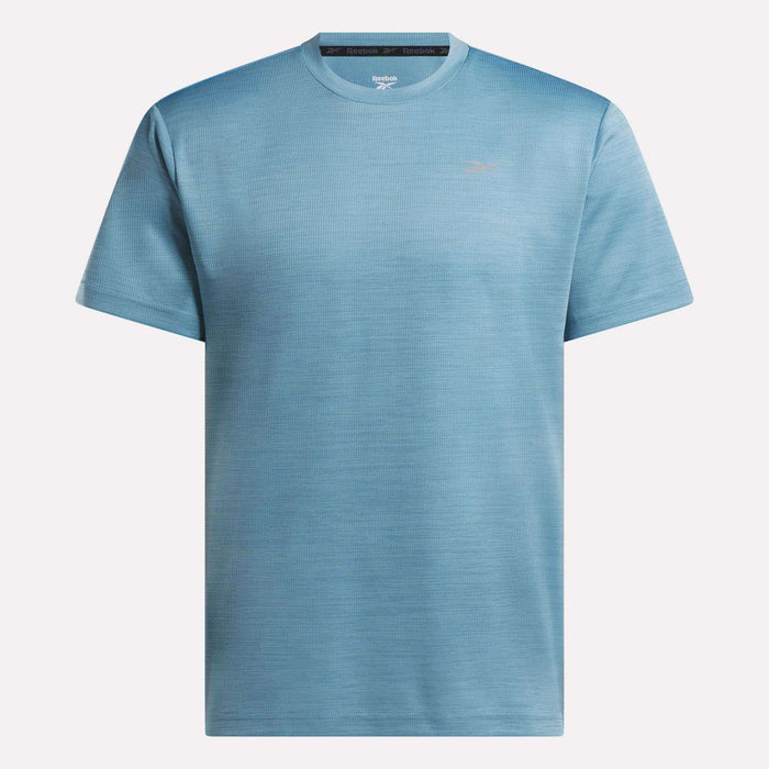 The Reebok Men's Director Short Sleeve Top is shown in light blue against a plain white background. This stretchy training tee has a simple design with a small left chest logo, ideal for everyday workouts.