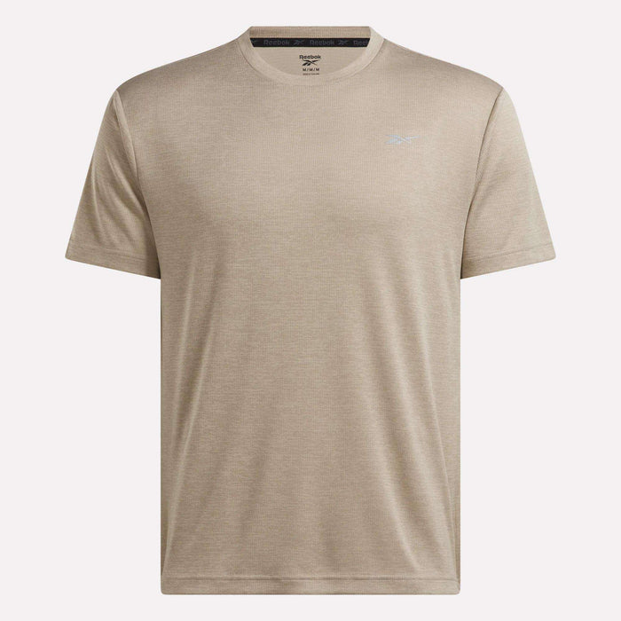 Men’s Director Short Sleeve Top by Reebok, featuring a beige color, crew neck, and short sleeves. This stretchy men’s workout shirt includes a subtle Reebok logo on the left chest and is showcased against a plain white background.