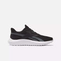 The Men's Energen Lux Running Shoes by Reebok feature a black mesh upper, white sole, and dark gray accents—versatile athletic sneakers ideal for running or everyday wear, shown from the side on a light background.