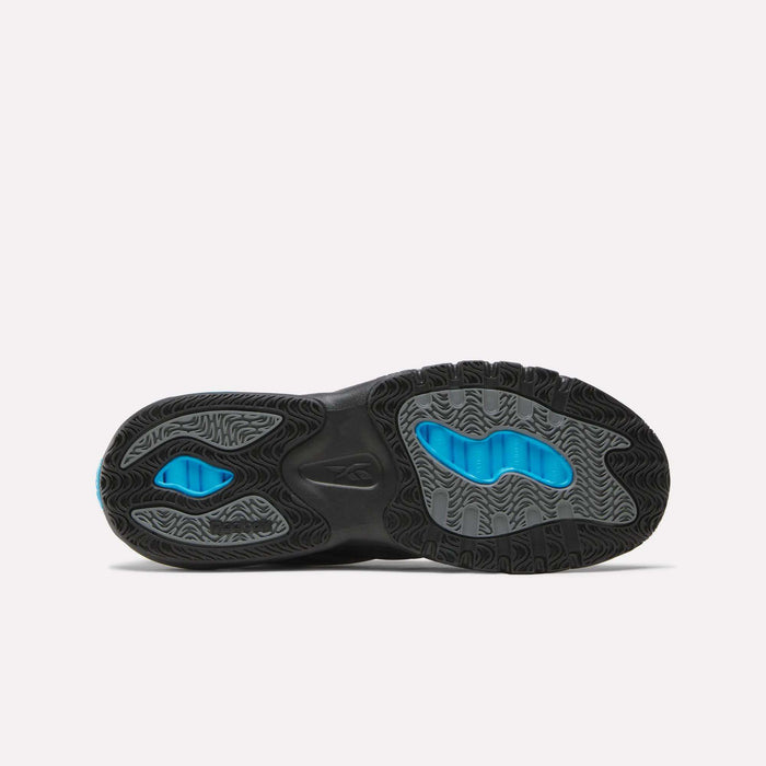 The image shows the black and grey rubber sole of Reebok Men's ERS Training Shoes, lying flat with blue accents at the heel and forefoot. Wavy tread patterns offer grip, reflecting premium cushioning perfect for training.