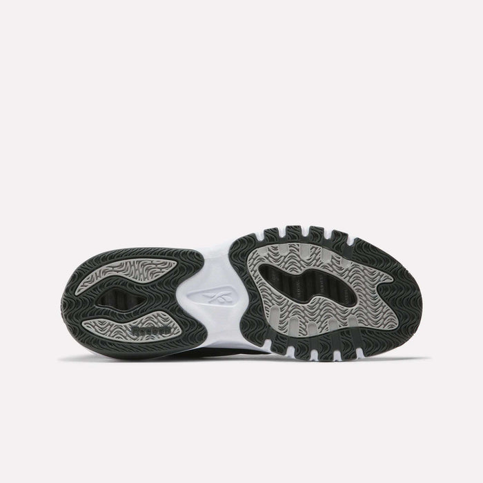 The image shows the outsole of Men’s ERS Training Shoes by Reebok, featuring a wavy, textured black and gray tread, premium cushioning, a white midsection, and the Reebok logo at the center on a plain white background.
