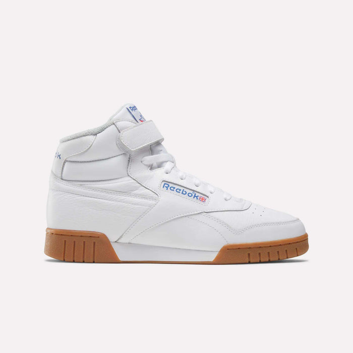 The Men's EX-O-FIT Hi Shoes by Reebok are white leather high-tops with a Velcro strap, blue and red Reebok branding, and a brown rubber sole, shown in side profile on a plain light background for a retro look.