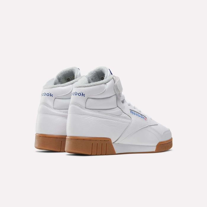A pair of Reebok Men's EX-O-FIT Hi Shoes in white leather with gum rubber soles, shown from the back and side on a plain white background. The classic design features blue and red Reebok branding on the heel and side.