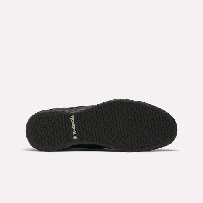 Men’s Exofit Lo Shoes by Reebok shown from the bottom, displaying a black low-profile design with a textured rubber sole and light Reebok branding near the heel on a plain, light background.