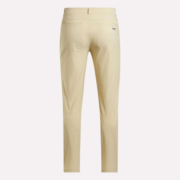 Back view of Reebok Men's Favorite 5-Pocket Relaxed Fit Golf Pants in light beige with RBK-DRY tech, two back pockets, and a small logo on the right pocket, displayed against a plain white background.