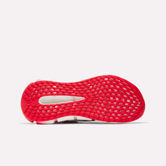 The image shows the red sole of the Reebok Men's FloatZig 2 AHA Running Shoes with a grid traction pattern and midfoot cutout, highlighting its energy-returning cushioning against a plain white background.