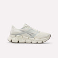 The Reebok Men's FloatZig 2 Running Shoes in light beige and white feature a chunky, segmented sole with Superfloat+ cushioning and Reebok branding, shown in side profile on a plain white background.
