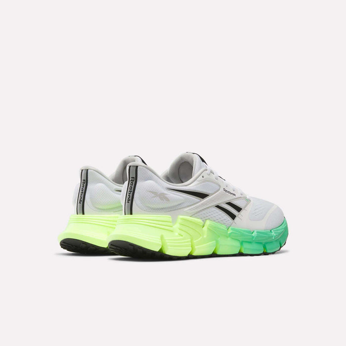 The Reebok Men's FloatZig 2 Running Shoes feature a white design with black accents and a chunky gradient sole transitioning from neon yellow to green, plus Superfloat+ cushioning, displayed on a plain white background.