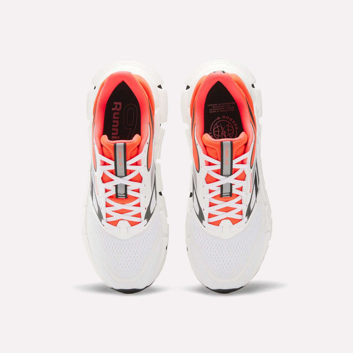 A pair of Reebok Men's FloatZig 2 Running Shoes with Superfloat+ cushioning, supportive white upper, orange inner lining, gray accents, and white laces is shown from above on a plain light background.