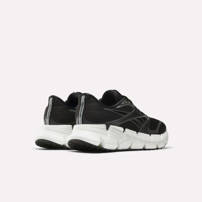The men's Reebok FloatZig 2 running shoes in black feature chunky white soles and Superfloat+ cushioning, displayed from back and side angles against a plain light background.