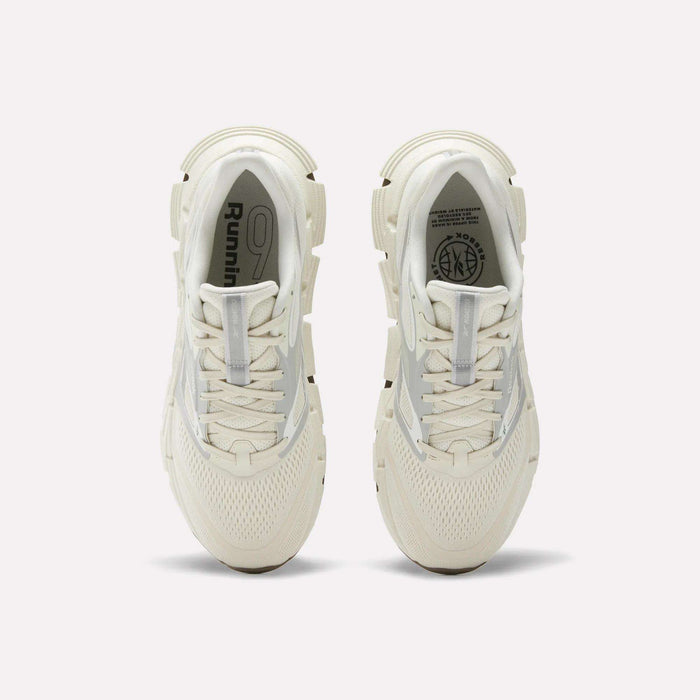 A pair of white Reebok Men's FloatZig 2 Running Shoes viewed from above, featuring mesh uppers, laces, cushioned Superfloat+ soles, and Running logo details on the insoles.