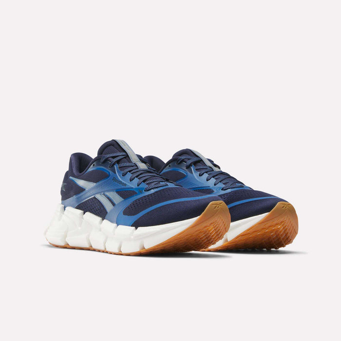 Men's FloatZig 2 Running Shoes by Reebok, in blue with white midsoles and brown gum soles. Features mesh and synthetic overlays plus Superfloat+ cushioning. Displayed on a plain white background.