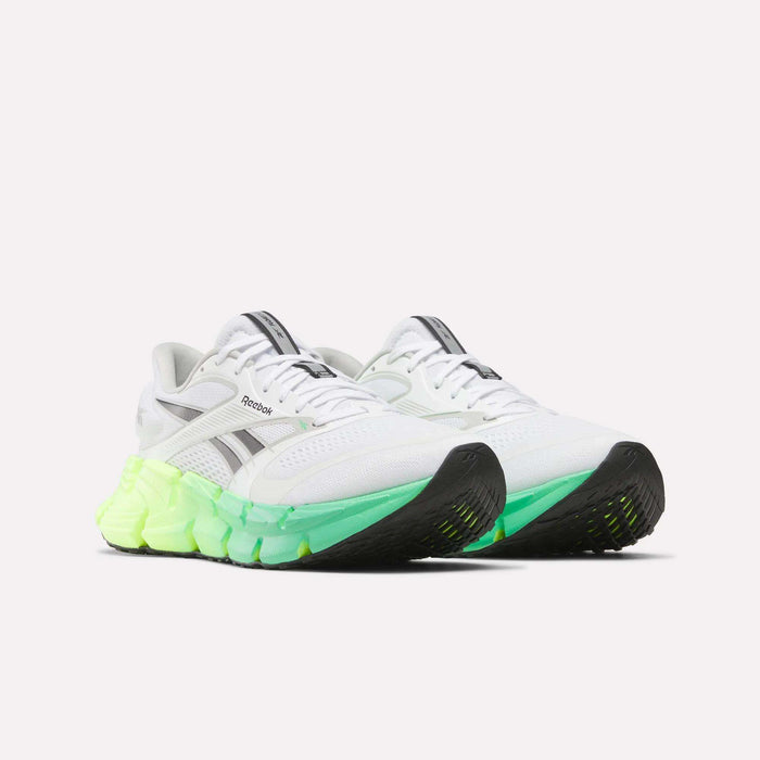 The Reebok Men's FloatZig 2 Running Shoes feature white mesh with black accents, a chunky sole that fades from neon green to yellow, black tread on toe and heel, and responsive Superfloat+ cushioning for all-day comfort.