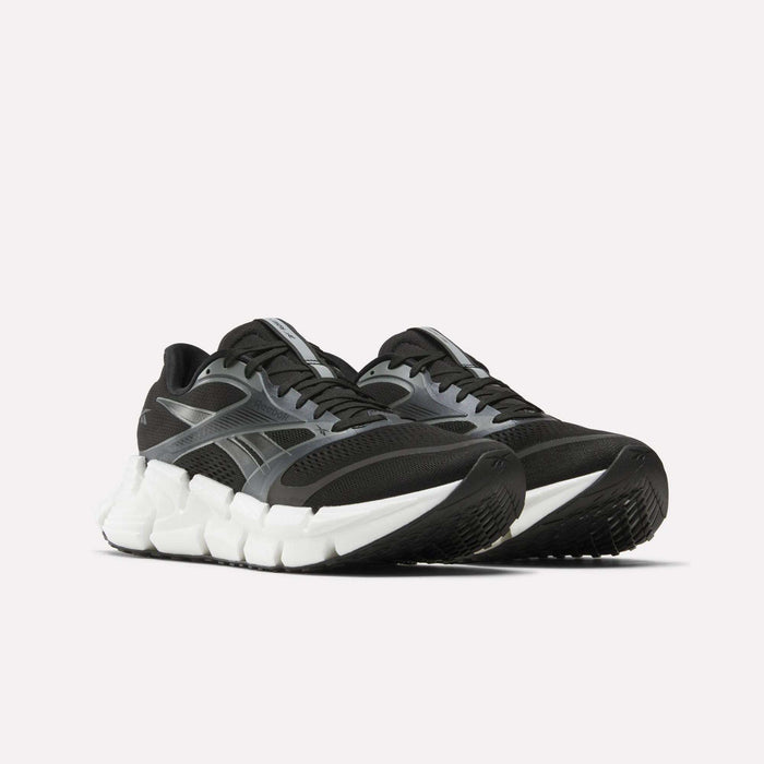 A pair of Reebok Men's FloatZig 2 Running Shoes in black and gray with thick white Superfloat+ cushioned soles, shown from a low front angle against a plain light background.
