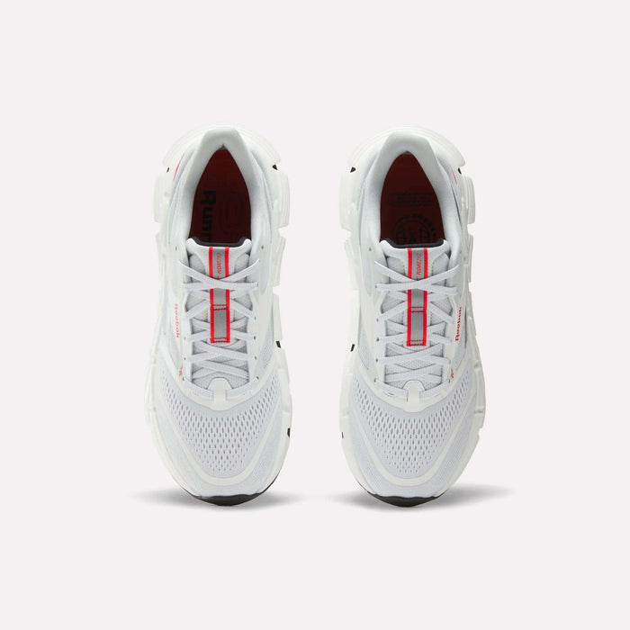 A pair of Reebok Men's FloatZig 2 Running Shoes in white, shown from above with red accents on the tongue and mesh details on the toe, placed side by side on a plain light background.