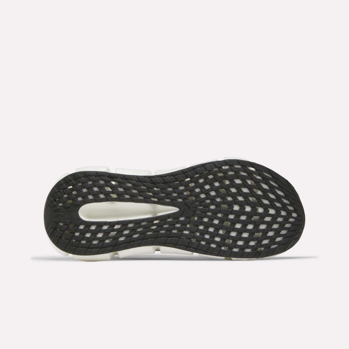 The image shows the black sole of the Reebok Men's FloatZig 2 Running Shoes with a white midsole and grid-like traction pattern, featuring Superfloat+ cushioning. The shoe is flat with the sole facing up on a plain white background.