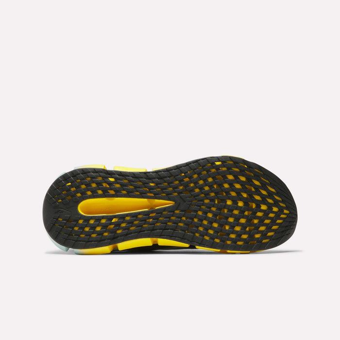 The image displays the sole of Reebok Men's FloatZig 2 Running Shoes, featuring a black and yellow grid-patterned tread for traction and Superfloat+ cushioning for comfort and performance, set against a plain white background.