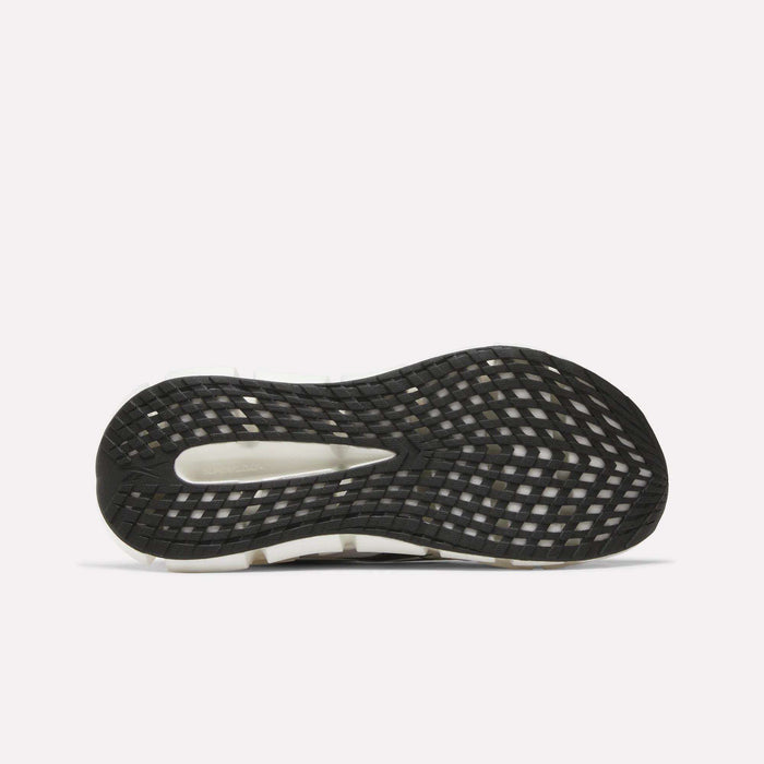 The image displays the outsole of men's Reebok FloatZig 2 running shoes with a black grid tread, center cutout, and white edge details, showcasing Superfloat+ cushioning for comfort against a plain white background.