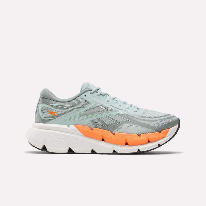 The Reebok Men's FloatZig Double Running Shoes are shown in profile, featuring light blue uppers with an orange accent above a thick white sole, designed for max-cushioned miles, against a plain white background.