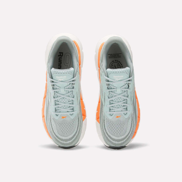 Top view of Reebok Men's FloatZig Double Running Shoes in light blue and gray with orange accents, white soles, and logo on the tongue—ideal max-cushion runners set against a light background.