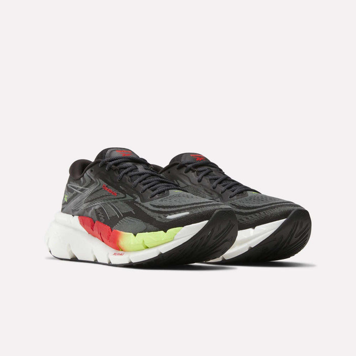 The Men’s FloatZig Double Running Shoes by Reebok are black with white, red, and yellow accents. They feature thick, max-cushioned white soles with a gradient of red and yellow near the midsole for standout style and comfort.