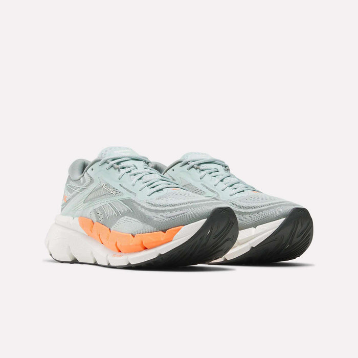 The Reebok Men's FloatZig Double Running Shoes feature light blue and gray mesh uppers, white and orange midsoles, black sole details, and offer max-cushioning—perfect for running. Displayed on a white background.