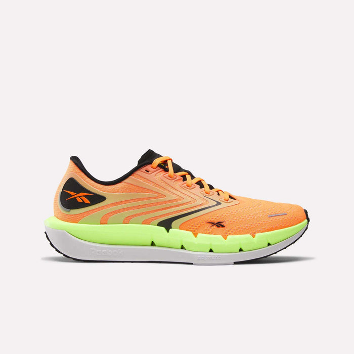 Reebok Men's FloatZig Tread Running Shoes in bright orange and yellow feature black accents, a wavy side pattern, cushioned midsole for comfort on treadmills, and a thick white/neon green sole, shown against a plain light background.