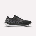 The Reebok Men's FloatZig Tread Running Shoes feature a black and gray design with a white sole, black laces, and a cushioned midsole, ideal for treadmill workouts. The Reebok logo is on the side against a plain white background.