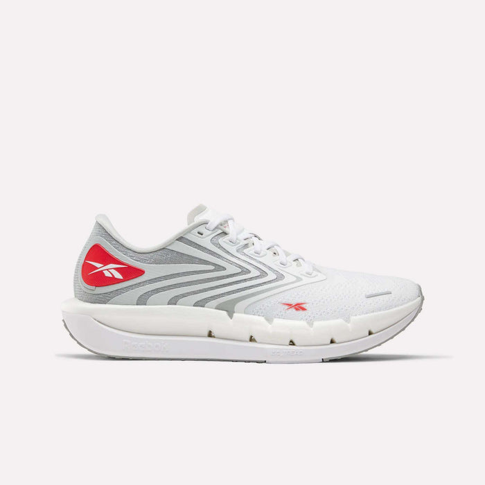 The Reebok Men's FloatZig Tread Running Shoes are white with gray and red accents, a mesh upper, wavy gray sides, red logos, and a thick cushioned midsole—ideal for treadmill workouts.