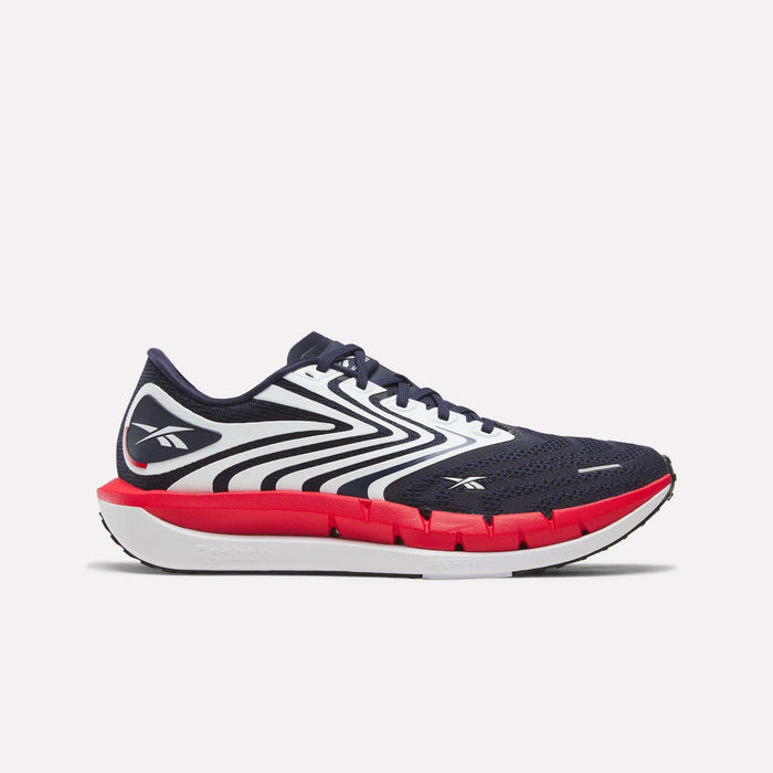 The Men's FloatZig Tread Running Shoes by Reebok are shown in side profile, featuring a navy blue and white wavy pattern, bold logo, red midsole, and white outsole—perfect for treadmill workouts or daily runs.