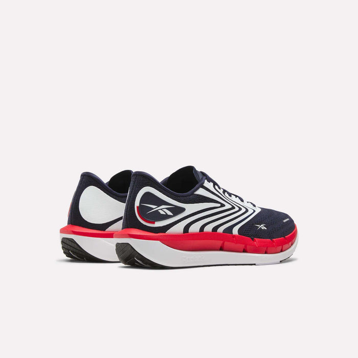 The Men's FloatZig Tread Running Shoes by Reebok feature a navy blue design with white and red accents, a white Reebok logo on the side, and are ideal for treadmill workouts. Shown against a plain white background.