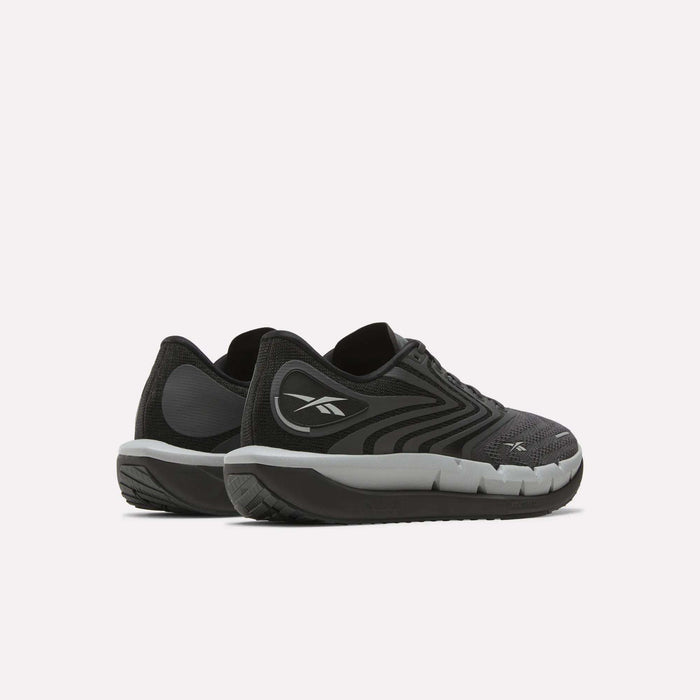 A pair of Reebok Men's FloatZig Tread Running Shoes in black and gray with white soles and a cushioned midsole are placed side by side on a light background—ideal for treadmill workouts.