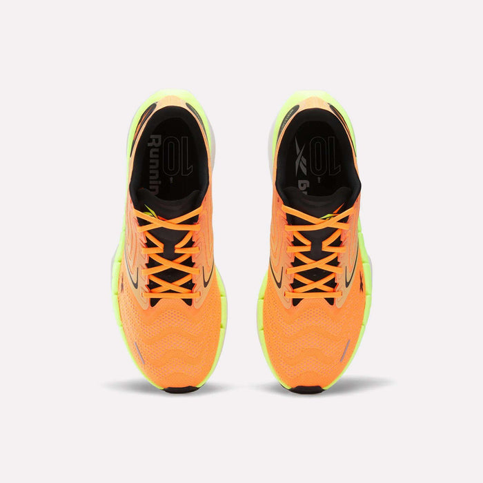 Top view of Men’s FloatZig Tread Running Shoes by Reebok in bright orange with neon yellow accents, black insoles, white soles, and a cushioned midsole—ideal for treadmill workouts—displayed side by side on a white background.