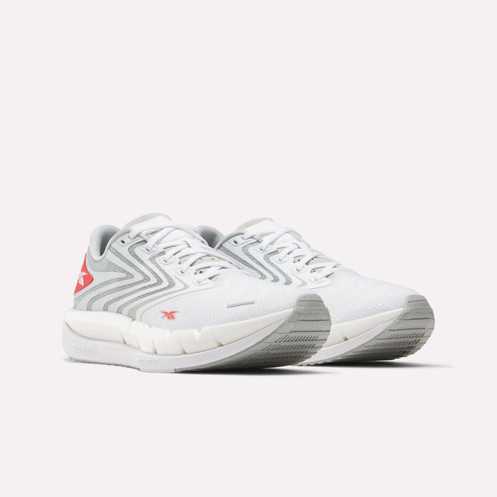 The Reebok Men's FloatZig Tread Running Shoes in white with light gray and red accents feature a zigzag side design, cushioned midsole, and textured sole—perfect for treadmill workouts—shown on a plain white background.