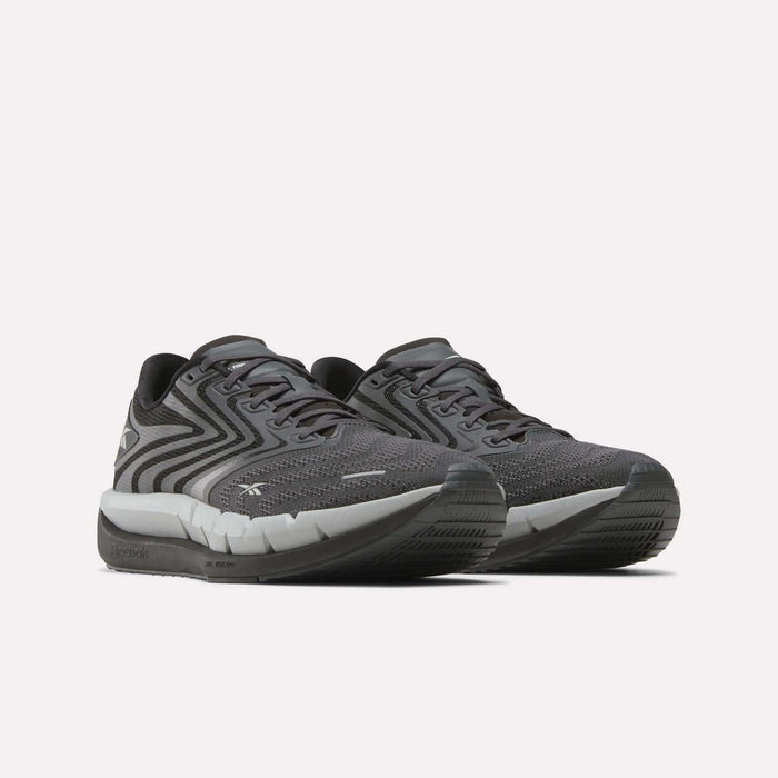 The Reebok Men's FloatZig Tread Running Shoes feature dark gray patterned mesh uppers, black laces, and a cushioned midsole—ideal for treadmill workouts—shown on a plain white background.