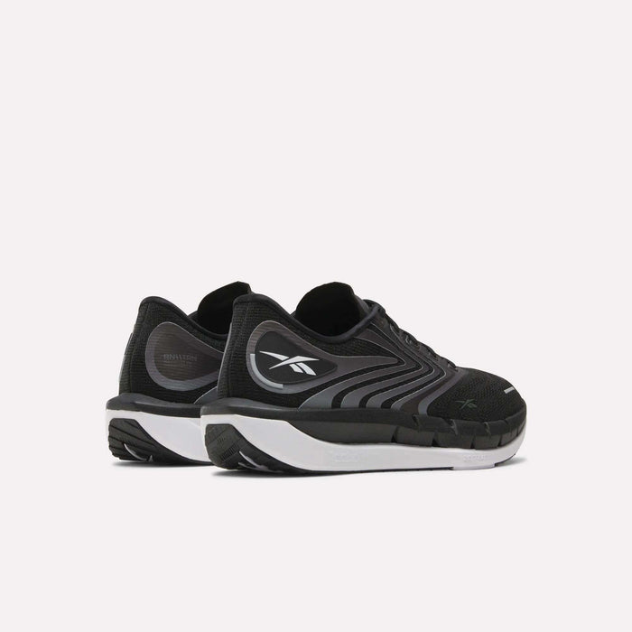 A pair of Men's FloatZig Tread Running Shoes by Reebok, featuring black uppers, cushioned midsoles, and white soles. The side and back view shows the Reebok logo, ideal for treadmill workouts.