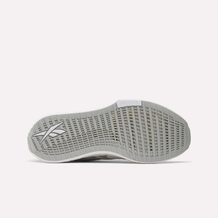 The image features the bottom view of a light grey Reebok Men's FloatZig Tread Running Shoe sole with a gridded tread and Reebok logo near the heel, perfect for treadmill workouts. The background is plain white.