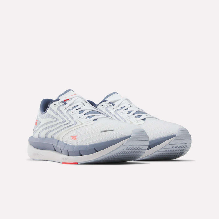 A pair of Reebok Men's FloatZig Tread Running Shoes in white with light gray and pink accents, lace-up closure, textured side pattern, and cushioned sole—ideal for running or treadmill workouts. Shown side by side on a light background.