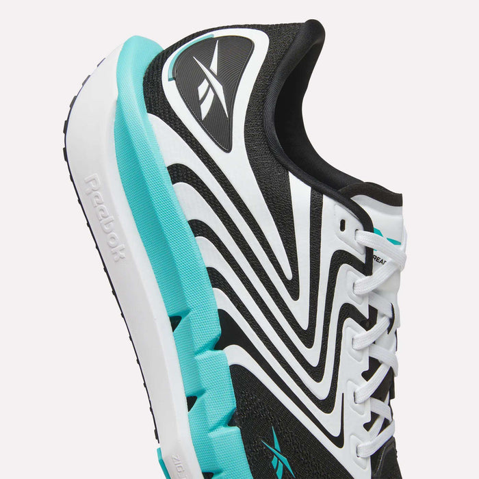Close-up of Reebok Men's FloatZig Tread Running Shoes in black and white with turquoise accents, featuring cushioned midsoles, wavy line design, white laces, and Reebok logos—perfect for treadmill workouts.