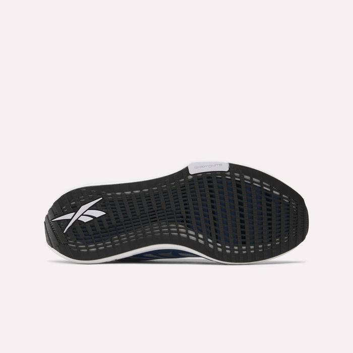 The image displays the black rubber outsole of Reebok Men's FloatZig Tread Running Shoes, with a white logo, grid-patterned tread for treadmill workouts, and a dual-density midsole visible along the edges.