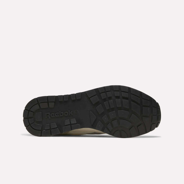The image displays the black rubber outsole of the Men’s GL1600 Shoes by Reebok, shown from the bottom to highlight the tread pattern and embossed Reebok branding.