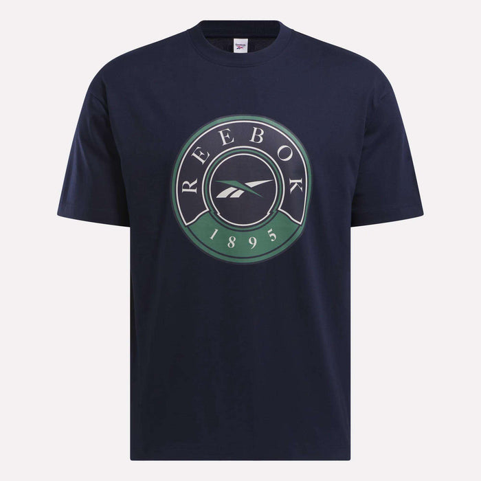 The Men's Lawn Club T-Shirt by Reebok is navy blue, made from luxe cotton, and features a large circular Lawn Club logo with REEBOK 1895 and a white Reebok vector symbol on the chest.