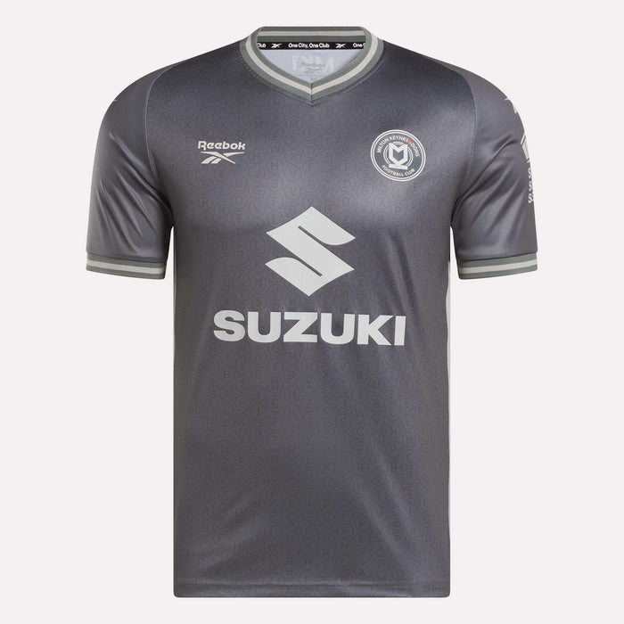 The Men's MK Dons Away Jersey by Reebok features a subtle gray pattern, a circular team crest on the chest, and SUZUKI across the front—a stylish soccer jersey inspired by Bletchley Park heritage.