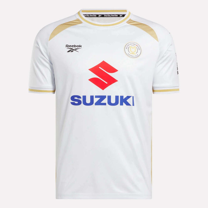 The Men's MK Dons Home Jersey by Reebok is a white football shirt with gold trim, a bold red Suzuki logo on the front, and a circular team crest on the left chest—an iconic piece for Milton Keynes fans.