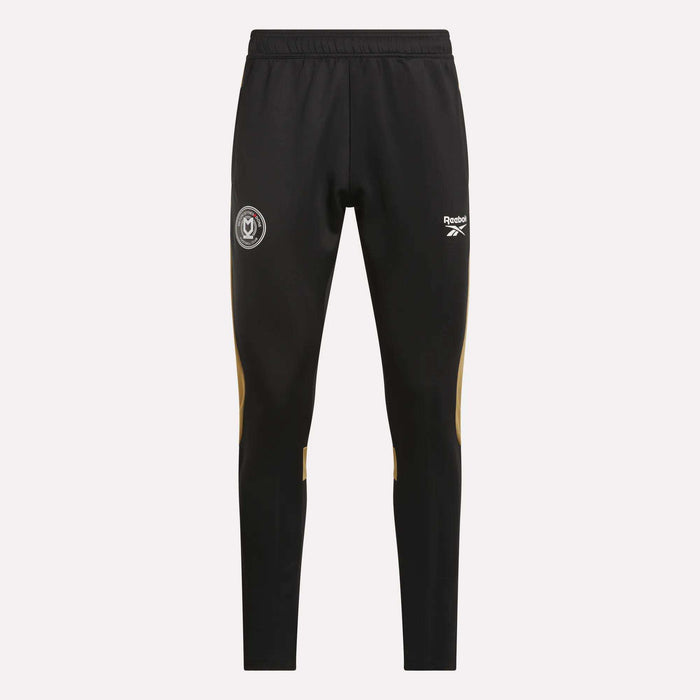 Reebok Men's MK Dons Travel Pants feature an elastic waistband, white logo and crest on the thighs, and yellow accents below the knees—ideal men's travel pants for dedicated football fans.