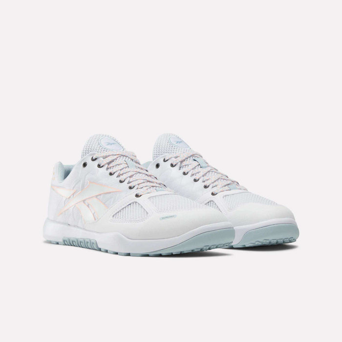 The Reebok Men's Nano 2.0 Training Shoes, in white with light blue soles and pastel pink accents, are designed for functional fitness and shown against a plain white background.