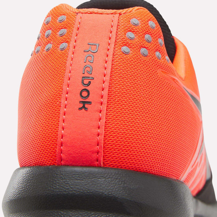 Close-up of the back of Reebok Men's Nano 2.0 Training Shoes in orange, showing the logo, textured fabric, gray dots, and black heel sole—ideal for functional fitness enthusiasts.