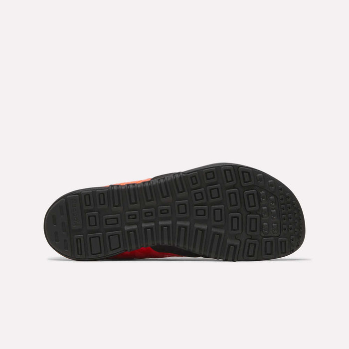 The image displays the bottom view of a black rubber sole from Reebok Men's Nano 2.0 Training Shoes, showing a geometric tread pattern against a plain, light-colored background.